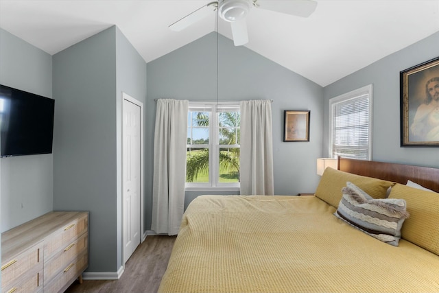 bedroom featuring baseboards, a ceiling fan, wood finished floors, vaulted ceiling, and a closet