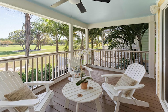 wooden terrace featuring ceiling fan and a lawn