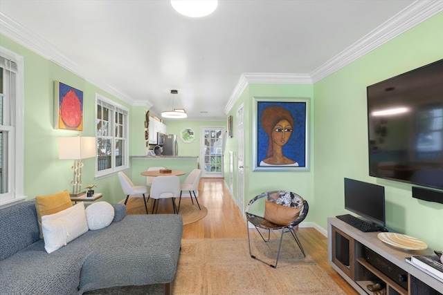 living area with light wood-style flooring, baseboards, and crown molding