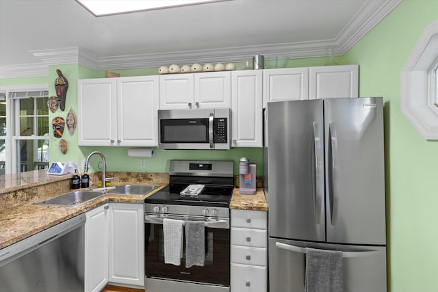 kitchen featuring crown molding, stainless steel appliances, a sink, and white cabinets