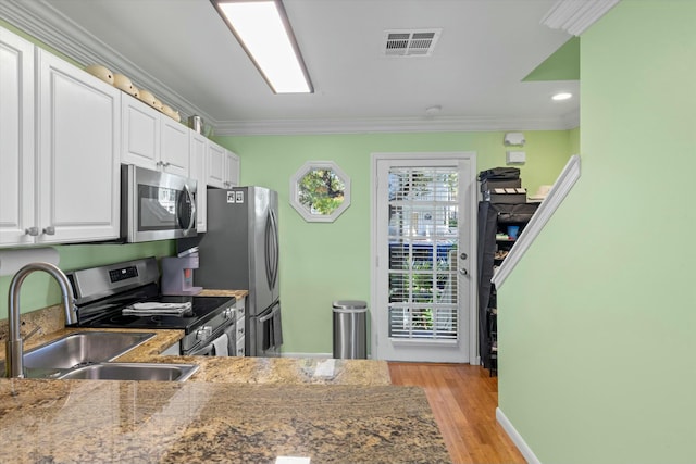 kitchen with visible vents, crown molding, appliances with stainless steel finishes, and a sink