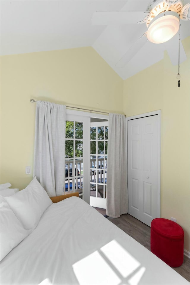 bedroom featuring a ceiling fan, lofted ceiling, wood finished floors, access to outside, and a closet