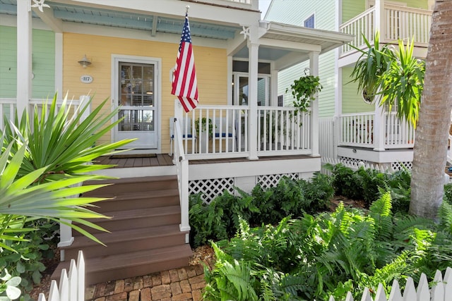 view of exterior entry featuring covered porch