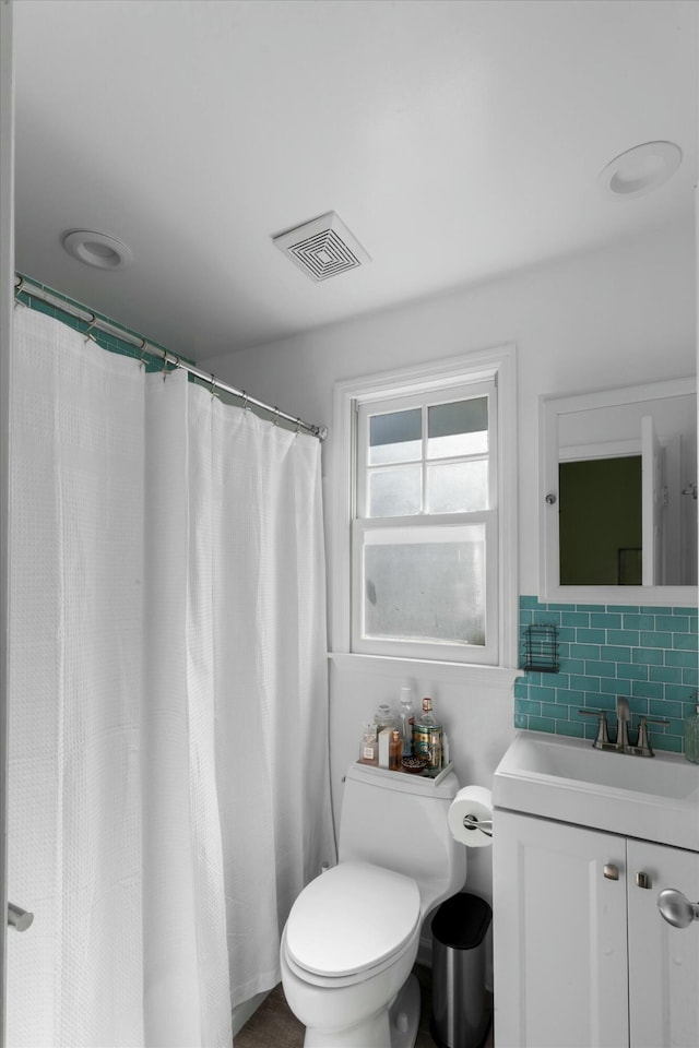 full bathroom featuring toilet, vanity, visible vents, a shower with curtain, and tasteful backsplash