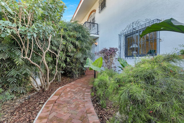 view of side of home featuring a balcony and stucco siding