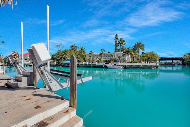 view of swimming pool featuring a dock, a water view, and boat lift