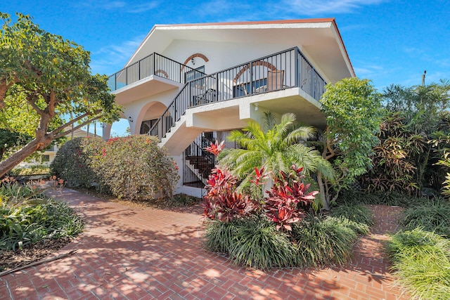 exterior space with stairway and stucco siding