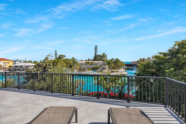 view of patio with a residential view, a water view, and a balcony