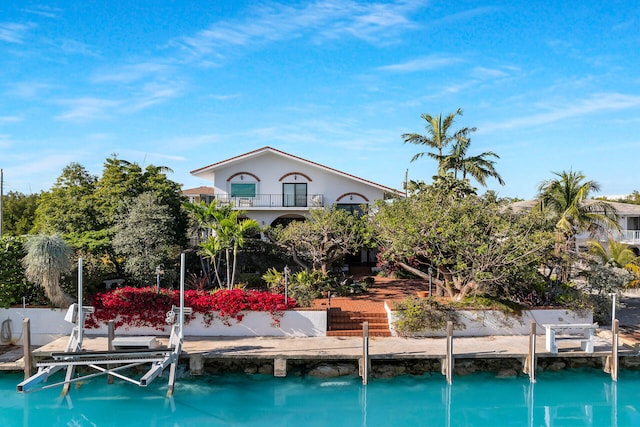 back of property featuring boat lift and a balcony