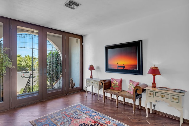 living area with french doors, wood finished floors, visible vents, and baseboards
