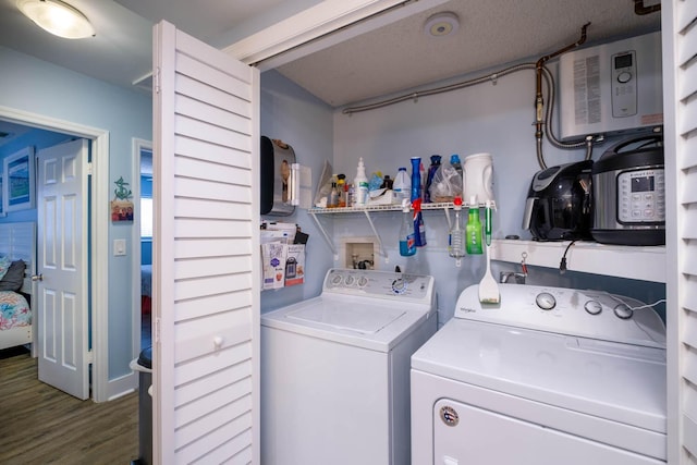 laundry area featuring washer and clothes dryer, laundry area, and wood finished floors