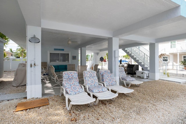 view of patio featuring a ceiling fan, stairs, and fence