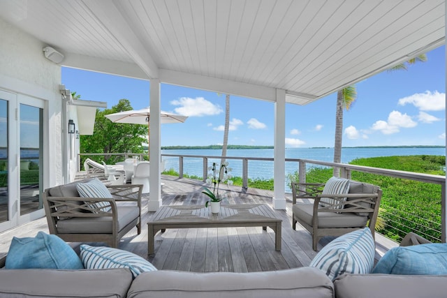 sunroom / solarium featuring a water view and beamed ceiling