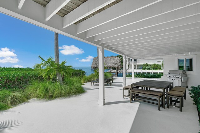 view of patio / terrace featuring area for grilling, a water view, and a grill