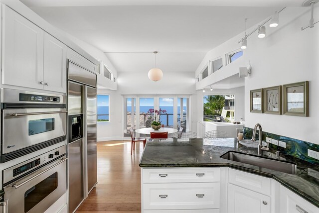 kitchen with white cabinetry, stainless steel appliances, light hardwood / wood-style floors, and sink