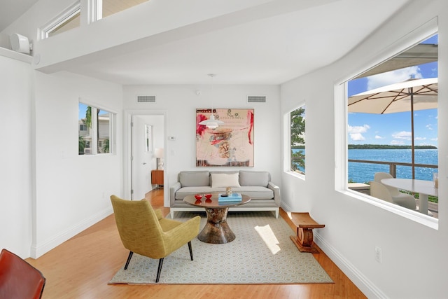 living room with wood-type flooring and a water view