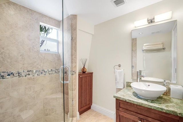 bathroom featuring vanity, tile patterned flooring, and a shower with door