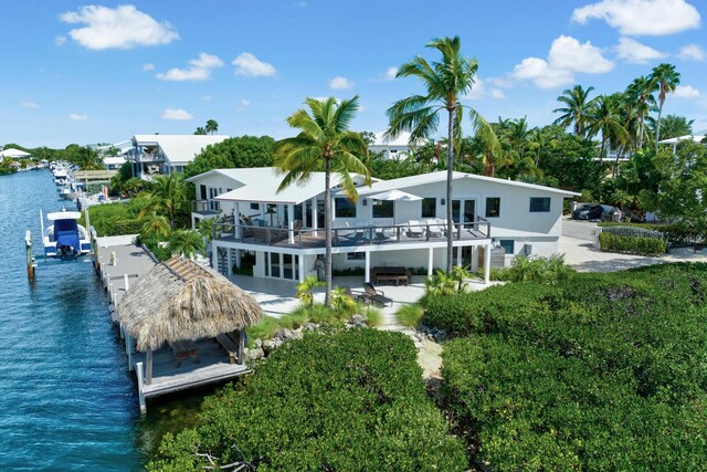 back of house featuring a water view and a patio area