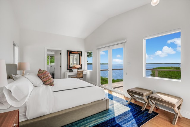 bedroom featuring a water view, wood-type flooring, access to exterior, and vaulted ceiling