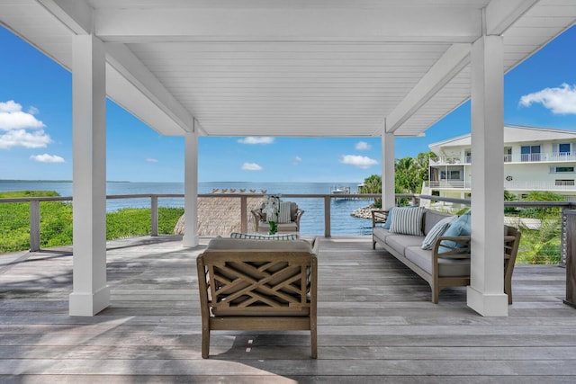 wooden terrace with a water view and outdoor lounge area