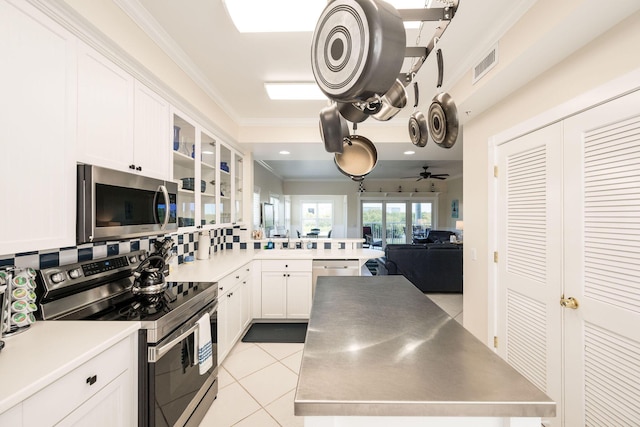 5960 Peninsular Ave Unit 101, Stock Island, FL 33040 - kitchen with appliances with stainless steel finishes, ornamental molding, white cabinetry, glass insert cabinets, and open floor plan