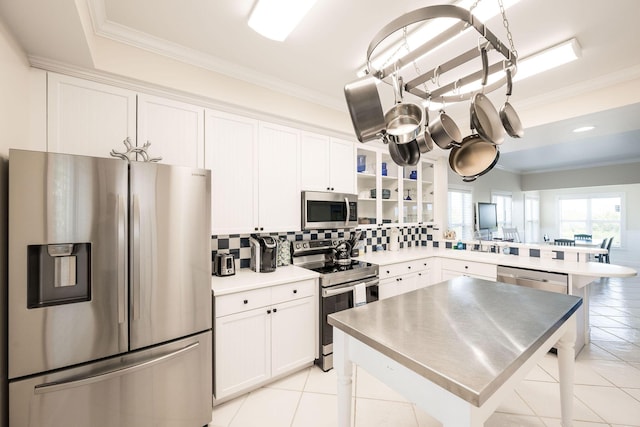 5960 Peninsular Ave Unit 101, Stock Island, FL 33040 - kitchen with appliances with stainless steel finishes, tasteful backsplash, light tile patterned floors, white cabinetry, and crown molding
