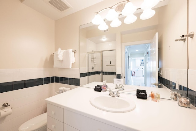 5960 Peninsular Ave Unit 101, Stock Island, FL 33040 - bathroom with tile walls, a stall shower, toilet, vanity, and a wainscoted wall