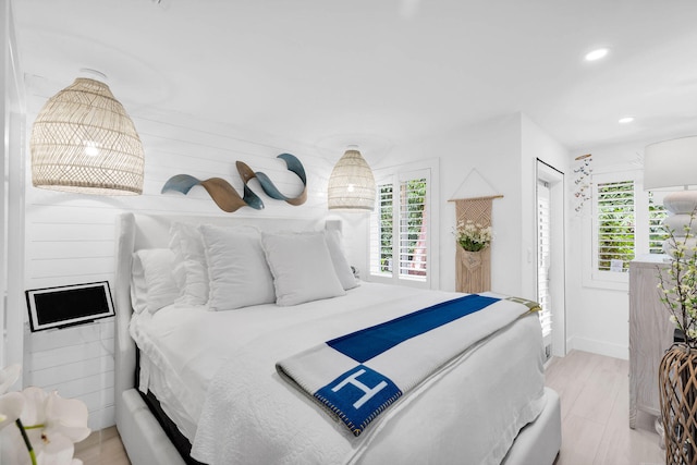 bedroom with multiple windows and light hardwood / wood-style floors