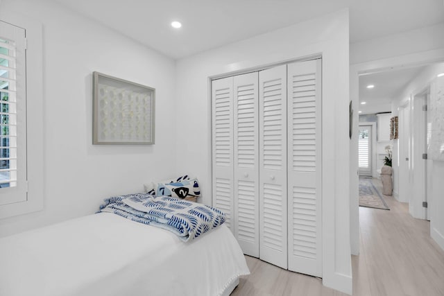 bedroom with light hardwood / wood-style floors and a closet