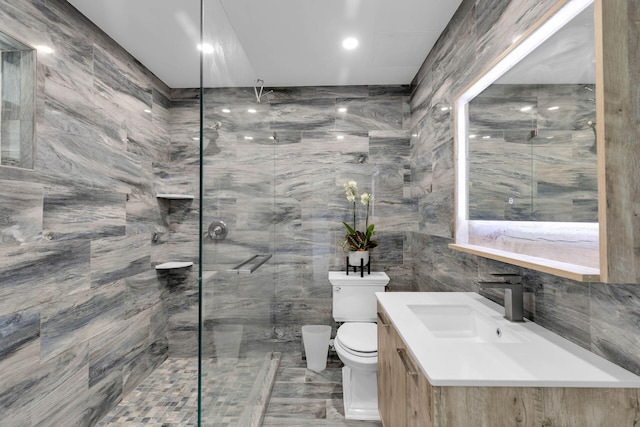 bathroom featuring tile walls, vanity, toilet, and tiled shower