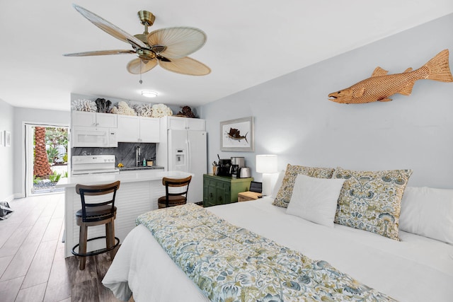 bedroom with hardwood / wood-style flooring, ceiling fan, white refrigerator with ice dispenser, and sink