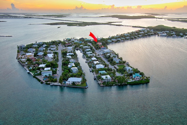 aerial view at dusk featuring a water view