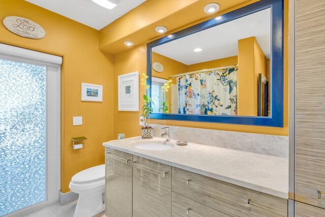 bathroom featuring vanity, curtained shower, tile patterned floors, and toilet