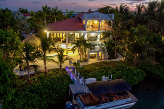 back house at dusk with a balcony