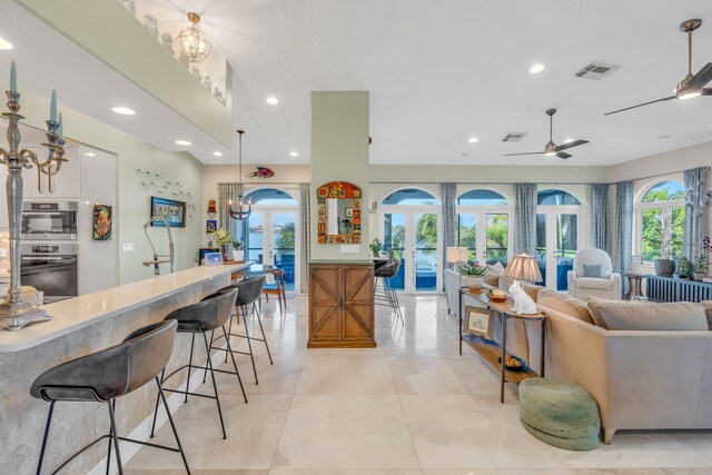 kitchen with decorative light fixtures, a healthy amount of sunlight, white cabinets, and french doors