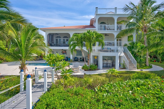 rear view of house featuring a balcony, ceiling fan, and a patio area