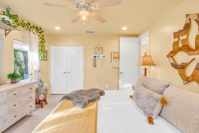 carpeted bedroom featuring ceiling fan and a closet