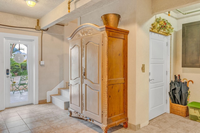 tiled entryway with a textured ceiling