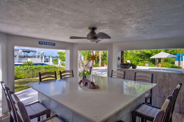 view of patio / terrace featuring an outdoor bar and ceiling fan