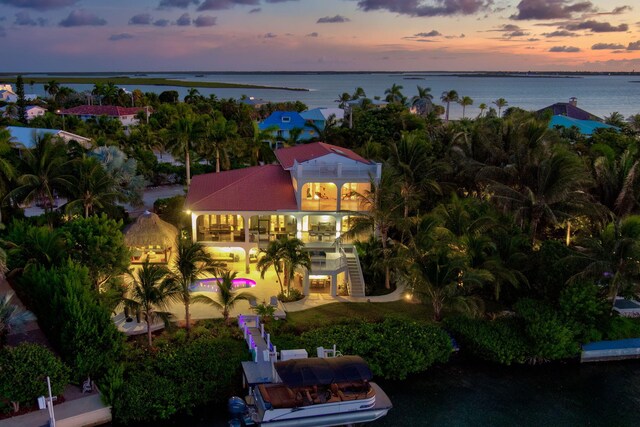 aerial view at dusk featuring a water view