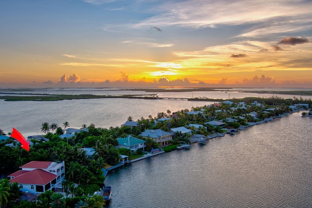 aerial view at dusk featuring a water view