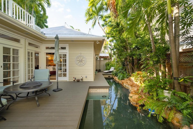 wooden terrace featuring fence, a fenced in pool, and french doors