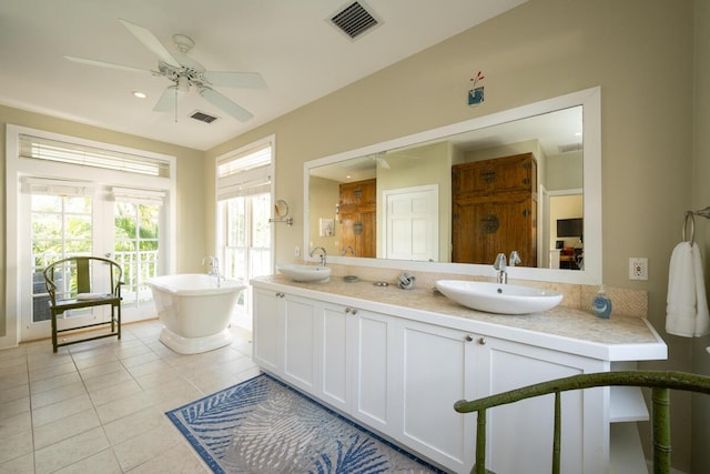 full bathroom featuring visible vents, a sink, a freestanding bath, and tile patterned floors