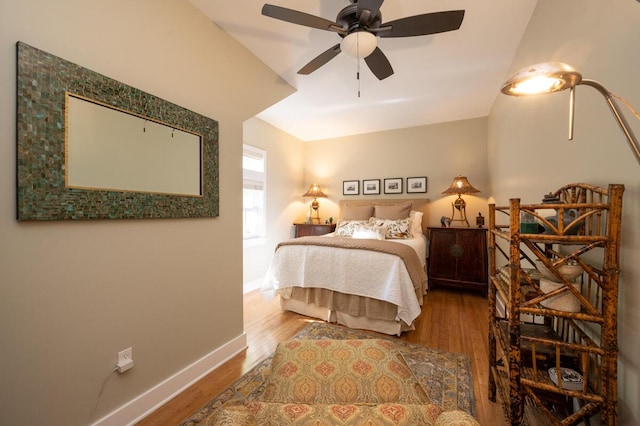 bedroom with a ceiling fan, baseboards, and wood finished floors