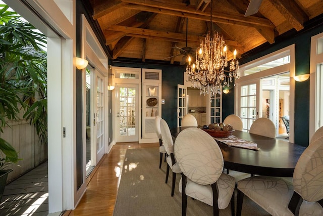 dining area with high vaulted ceiling, a notable chandelier, wood finished floors, french doors, and beam ceiling