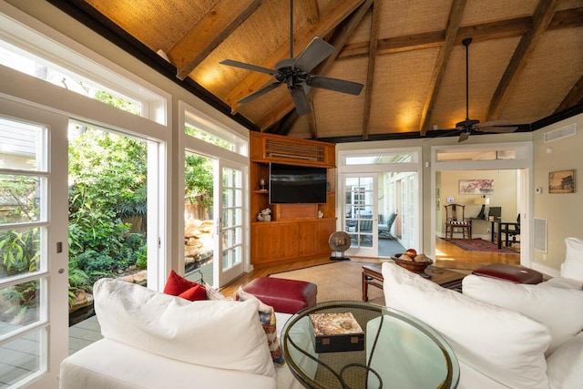 living area featuring a healthy amount of sunlight, wood ceiling, visible vents, and beamed ceiling