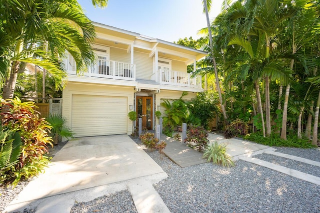 view of front of house featuring an attached garage, a balcony, and concrete driveway