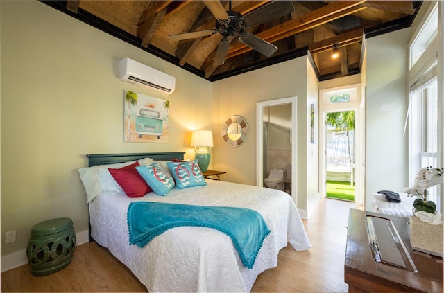 bedroom featuring a wall unit AC, wood finished floors, beam ceiling, and baseboards