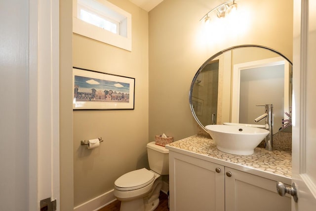 bathroom with vanity, toilet, and baseboards