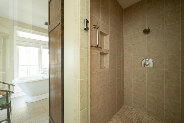 full bathroom with a freestanding bath, a tile shower, and tile patterned floors